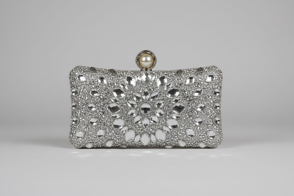 Silver clutch bag with intricate design and pearl clasp