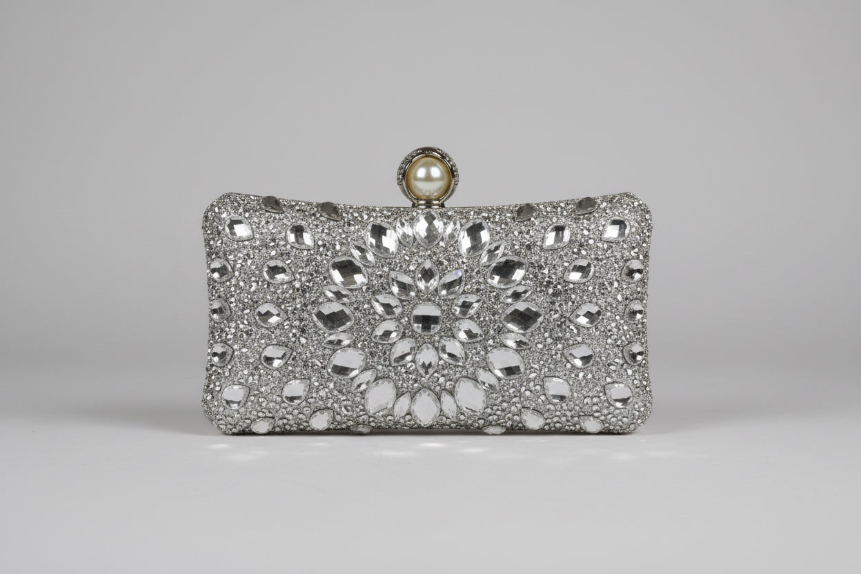 Silver clutch bag with intricate design and pearl clasp