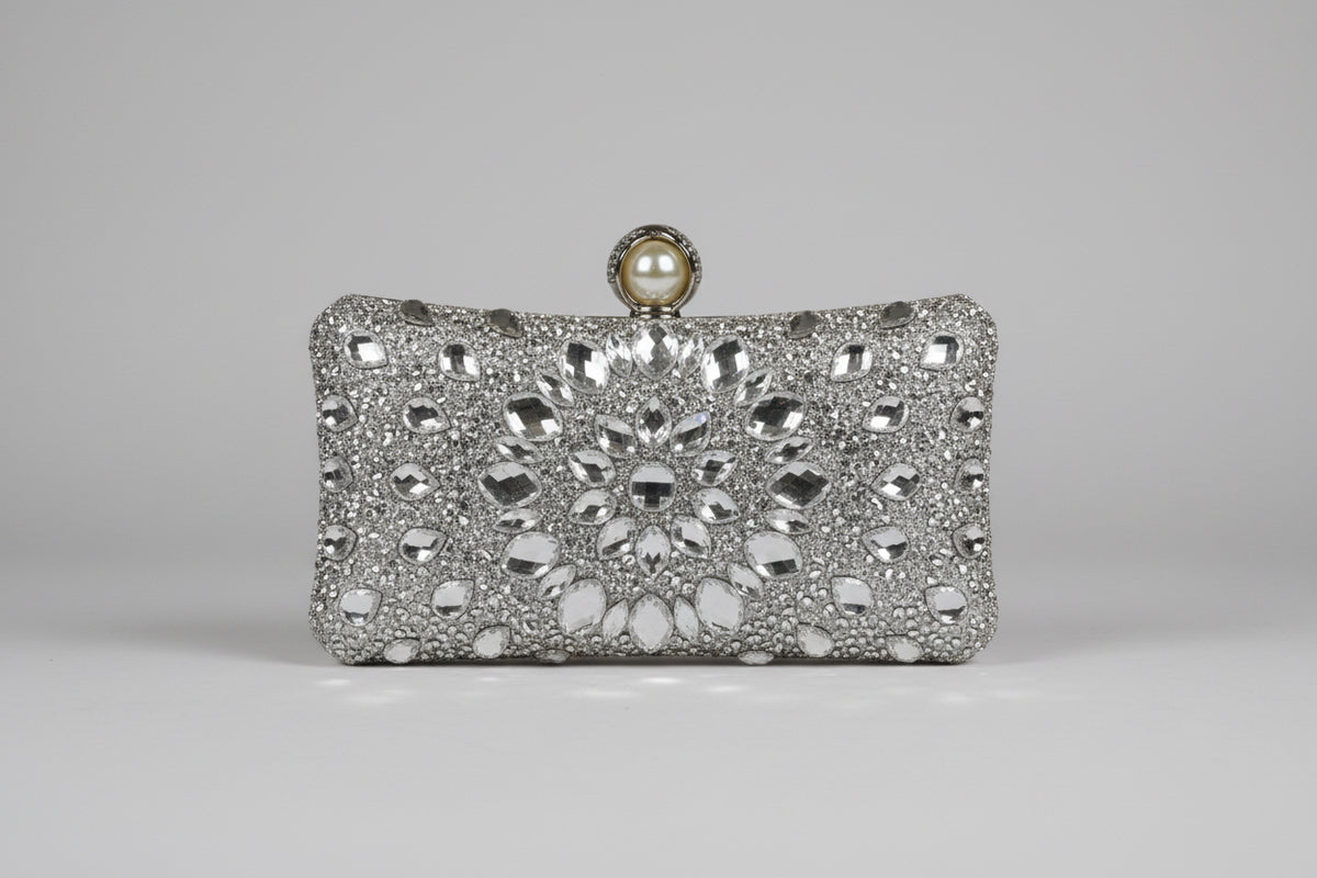 Silver clutch bag with intricate design and pearl clasp